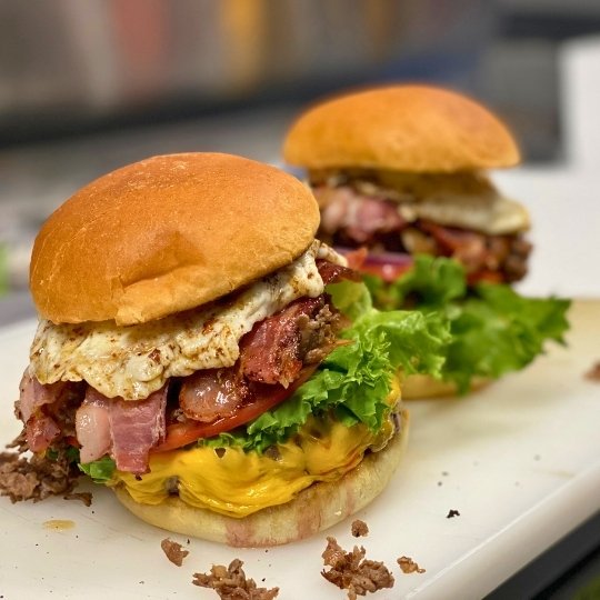 Cheeseburgers on be prepared in the kitchen at Happy Valley LIVE. Angus beef burgers